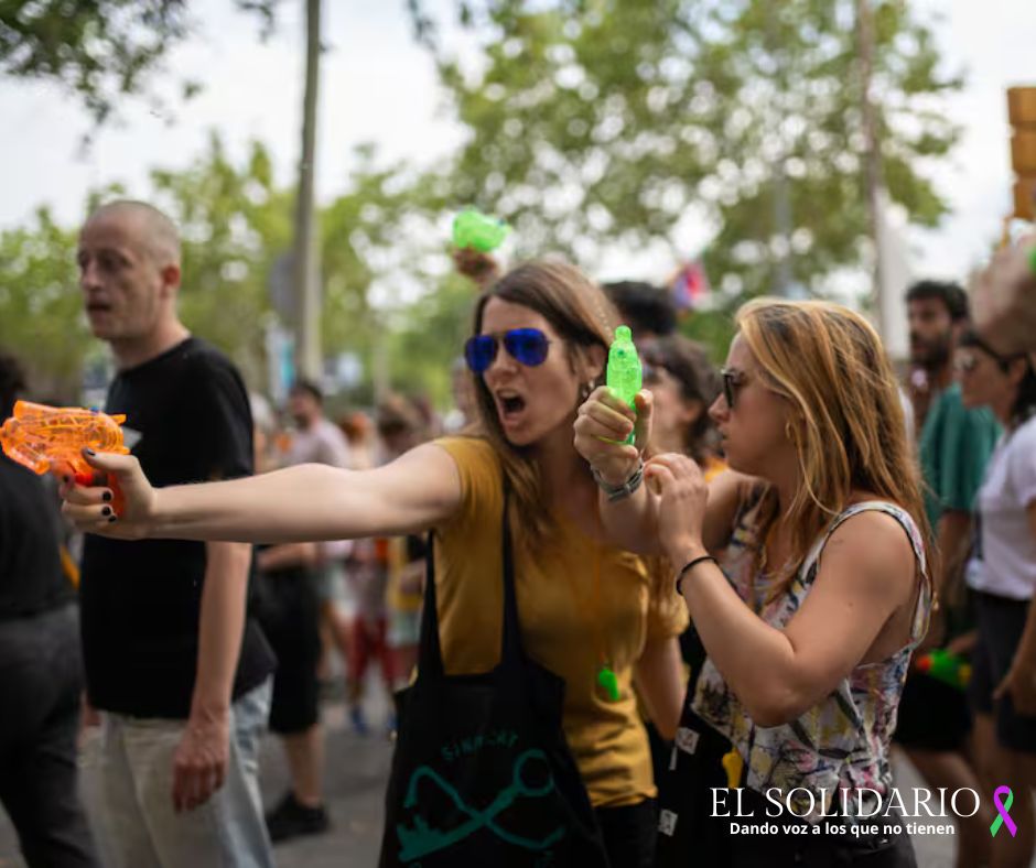 Dos mujeres rocían con agua a los turistas durante la manifestación de Barcelona.