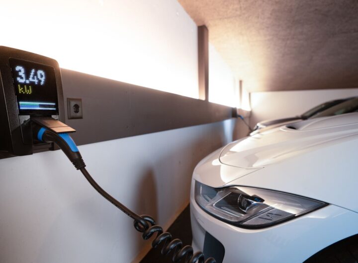 White electric car charging at indoor station, emphasizing sustainability and efficiency.