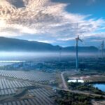 Stunning aerial view of wind turbines and solar panels in a landscape, showcasing renewable energy technologies.