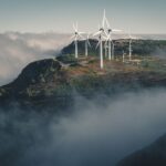 Wind turbines amidst fog and clouds in Madeira, Portugal create a captivating natural scene.
