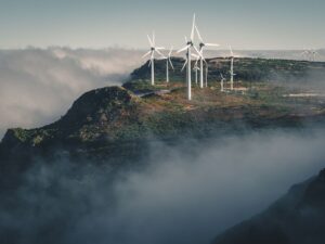 Wind turbines amidst fog and clouds in Madeira, Portugal create a captivating natural scene.