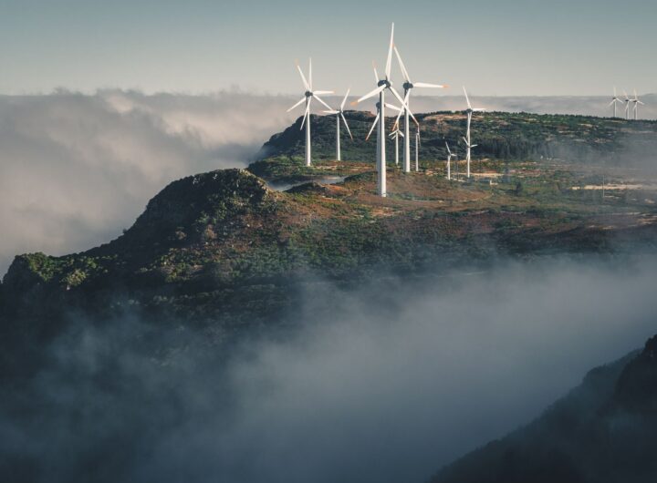 Wind turbines amidst fog and clouds in Madeira, Portugal create a captivating natural scene.
