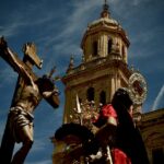 A jesus statue is next to a cathedral.