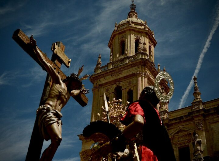 A jesus statue is next to a cathedral.