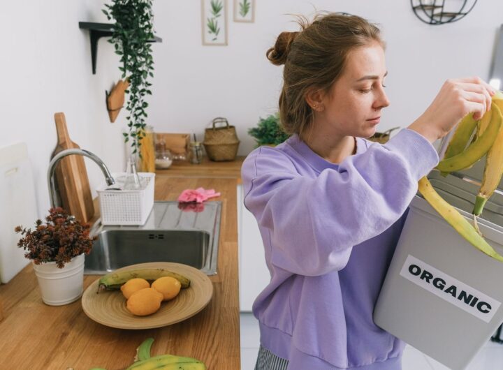 A woman composts banana peels in an indoor organic bin, promoting sustainable living.
