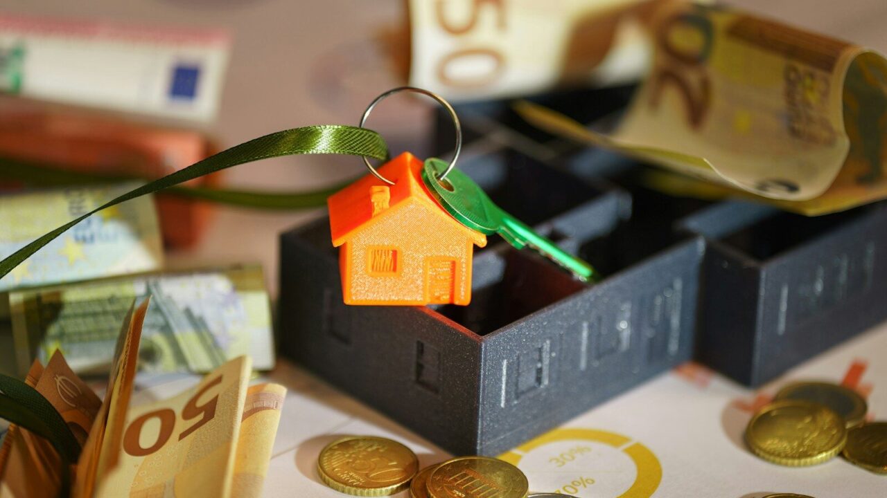 A small house on top of a pile of money