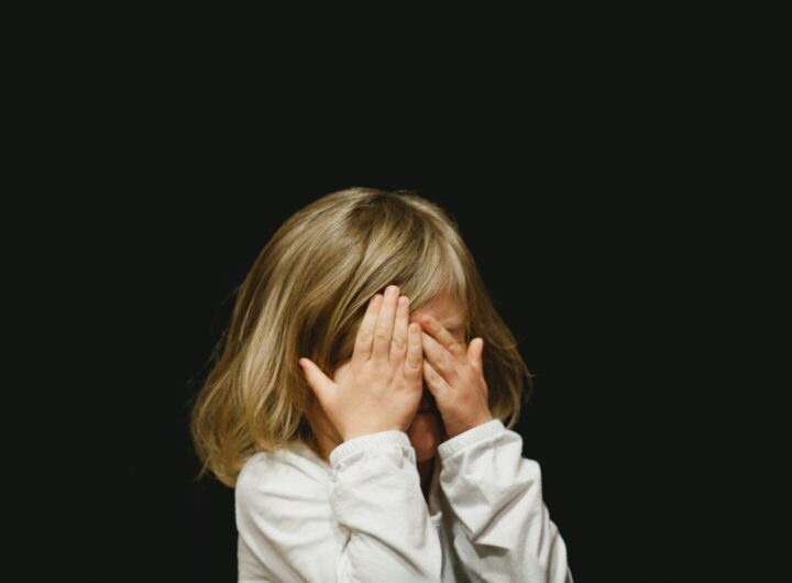 girl covering her face with both hands