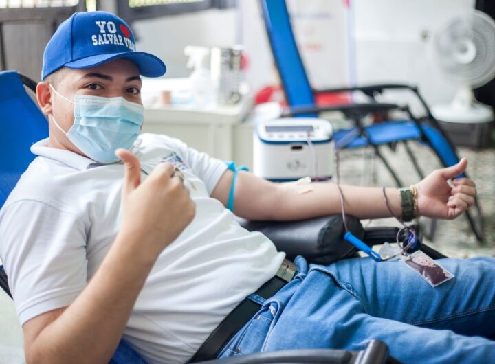 Man donating blood while giving a thumbs up, promoting blood donation in a friendly setting.