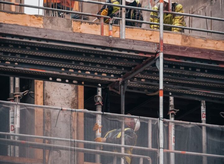 Construction workers engage in building tasks on a scaffold in Hamburg.
