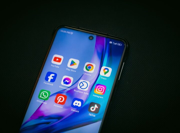 Close-up of a smartphone screen showing popular app icons like YouTube, Maps, and TikTok on a black background.