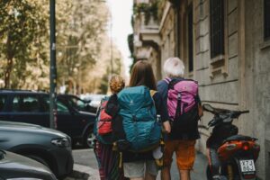 Two people with backpacks walking down the street