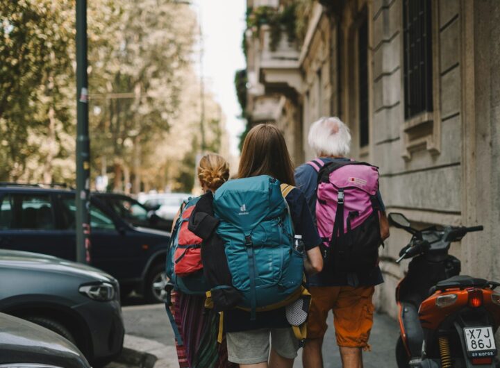 Two people with backpacks walking down the street