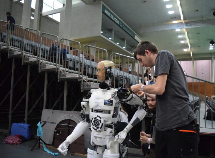 Technician working on humanoid robot at a tech exhibition in Guimaraes, Portugal.