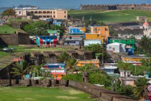 A vibrant view of the colorful La Perla neighborhood against historic San Juan fortifications.