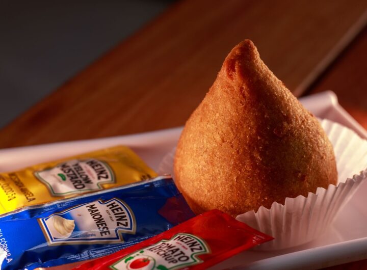 Delicious Brazilian coxinha served with mustard, mayonnaise, and ketchup packets.
