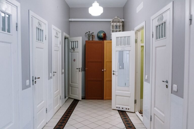 A modern hallway with white doors and cabinets, offering elegant interior design.