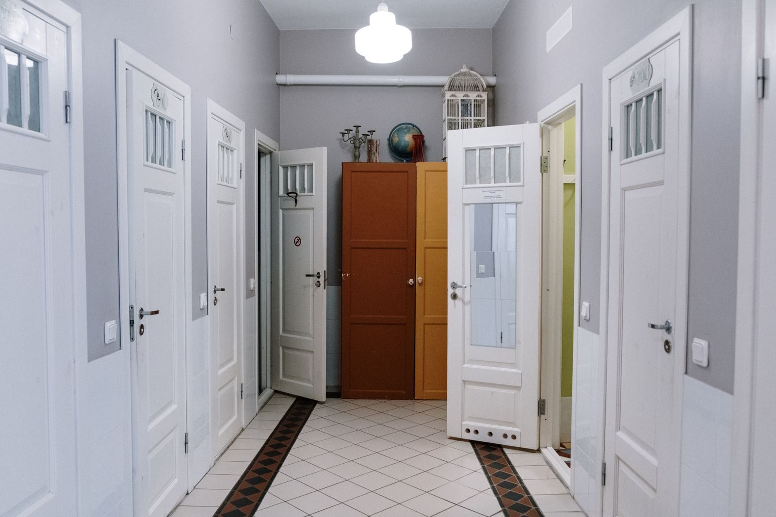 A modern hallway with white doors and cabinets, offering elegant interior design.